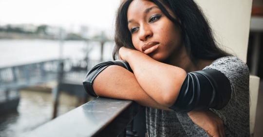upset woman staring off her balcony
