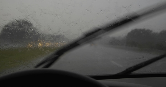 driver in the rain with windshield wipers